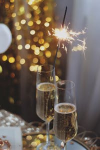 Close-up of champagne glasses with sparklers for a festive celebration.